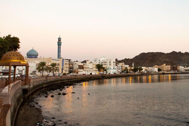Historic buildings and a mosque in Muscat Oman along the waterfront at sunset