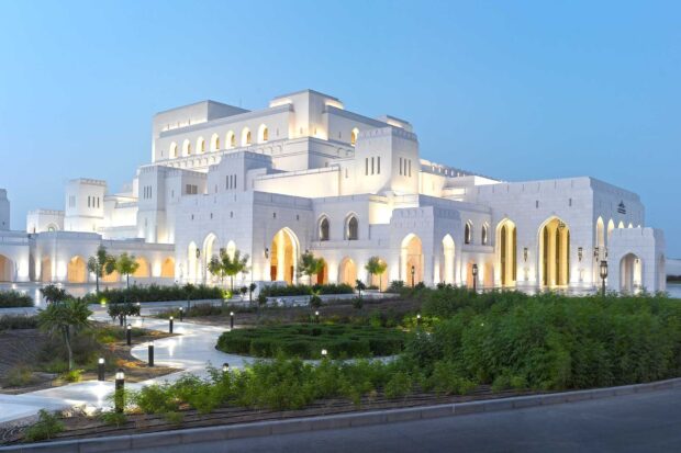 The grand architecture in Muscat Oman illuminated at dusk with lush greenery
