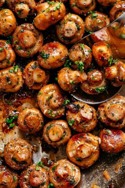 Sautéed mushrooms seasoned with herbs and spices cooking in a pan