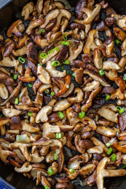 Sautéed mushrooms with green onions cooked to perfection in a pan