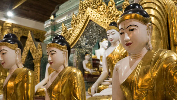 Golden Buddha statues inside a Myanmar temple showcasing traditional craftsmanship and culture