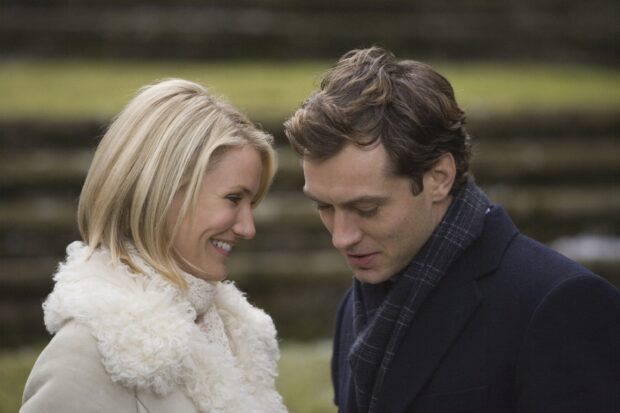 A warm moment between a couple in a Nancy Meyers setting outside in winter clothes