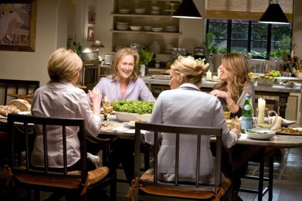 Women enjoying a lively dinner conversation in a cozy kitchen setting