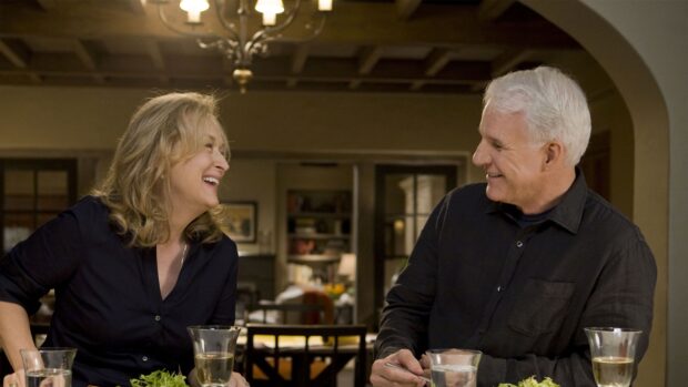 A joyful moment of a middle aged couple laughing together at a dining table in a cozy kitchen setting