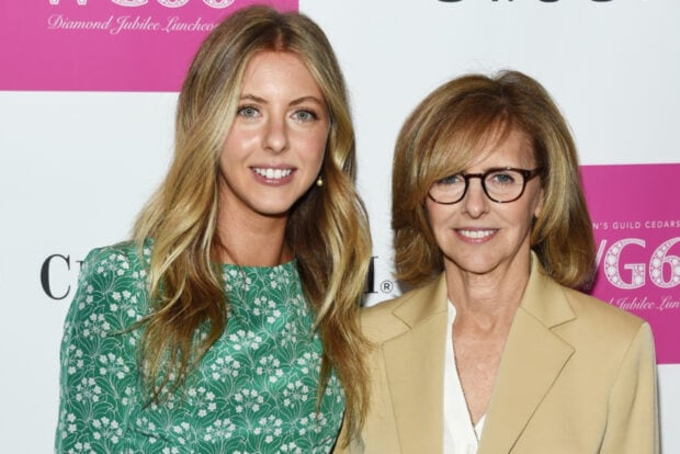 Nancy Meyers with a young woman smiling together at an event with a pink and white background