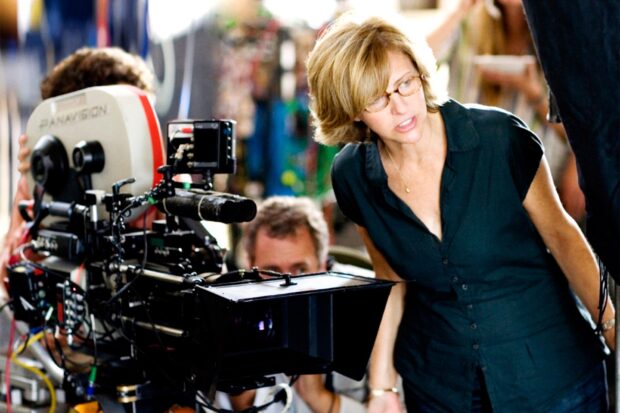 Nancy Meyers directing a film scene on set with a professional camera in a studio environment