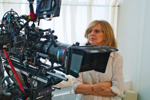 Nancy Meyers watching a film camera on set with arms crossed