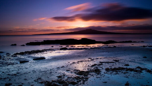 A National Geographic island landscape at sunset with vibrant colors and calm sea