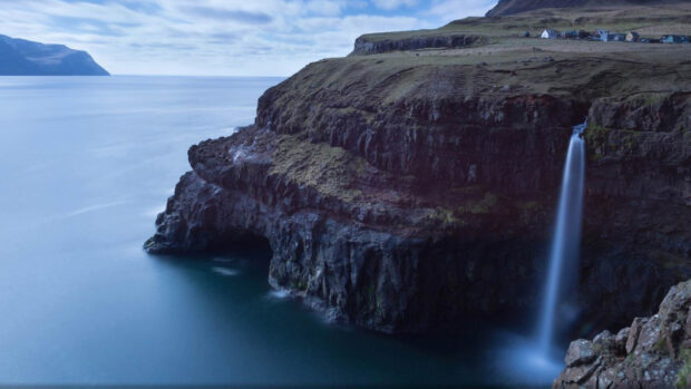 A waterfall flowing over rocky cliffs in a National Geographic landscape