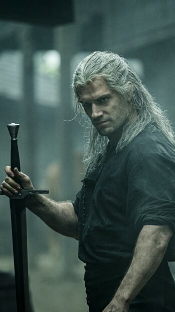 Geralt of Rivia holding a sword in a dark environment from Netflix series The Witcher