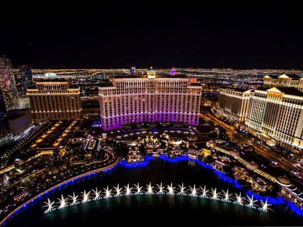 A nighttime view of Nevada cityscape with illuminated buildings and fountain show