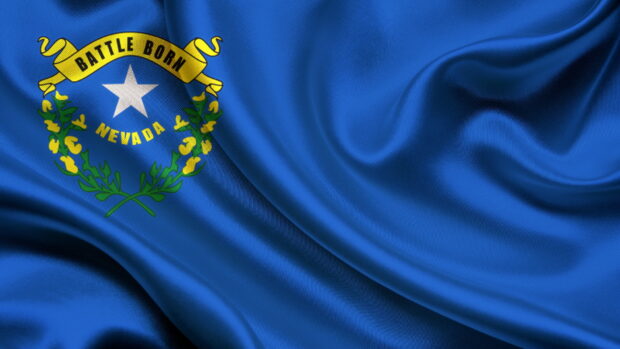 The Nevada state flag waving on blue fabric with a white star and yellow banner