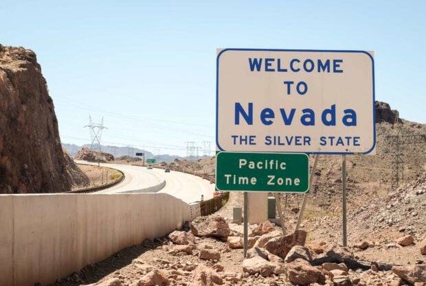 Road sign welcoming drivers to Nevada in the desert landscape