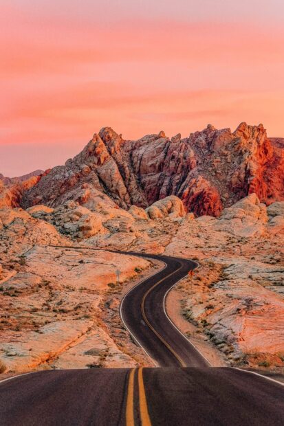 Winding road through rocky terrain of Nevada desert at sunset