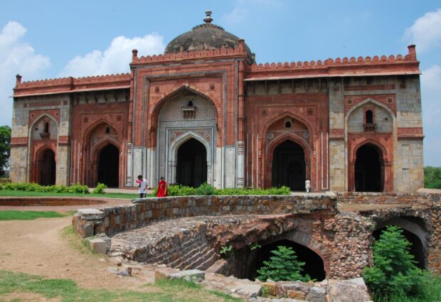 Ancient architectural monument in New Delhi surrounded by greenery and people walking nearby