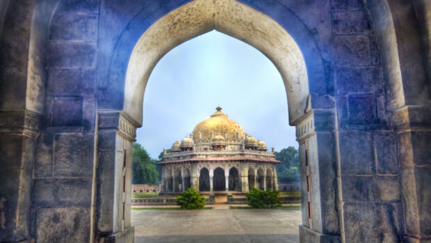 View of historic New Delhi architecture framed by stone arch with New Delhi monument in the background