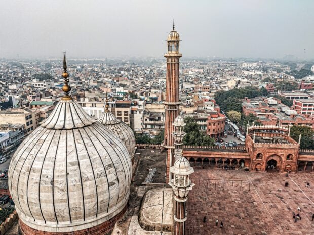 Historical architecture and cityscape of New Delhi with mosque domes and minarets overlooking urban area
