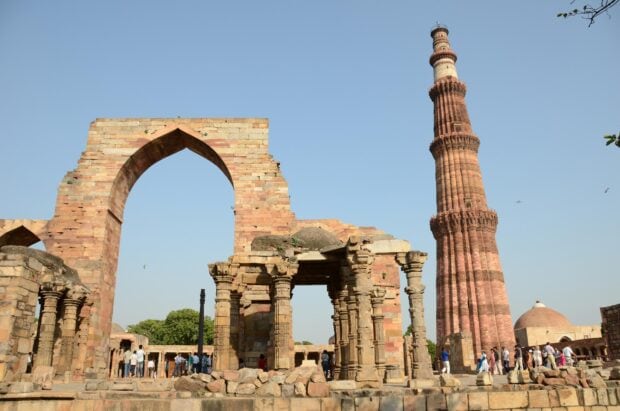 Ancient ruins and historic tower in New Delhi with clear blue sky