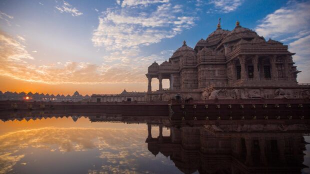 Stunning Hindu temple architecture in New Delhi during a colorful sunset reflection