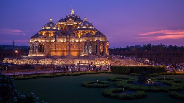 The illuminated Akshardham temple in New Delhi during sunset showcasing stunning architecture