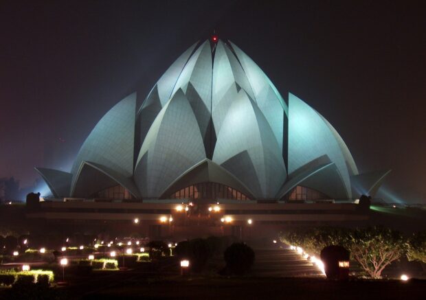 The illuminated Lotus Temple in New Delhi at night showcasing its unique architectural design