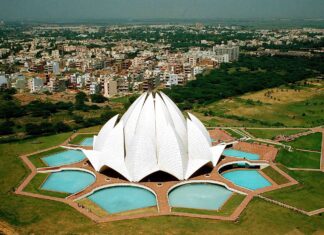 An aerial view of Lotus Temple in New Delhi surrounded by gardens and cityscape
