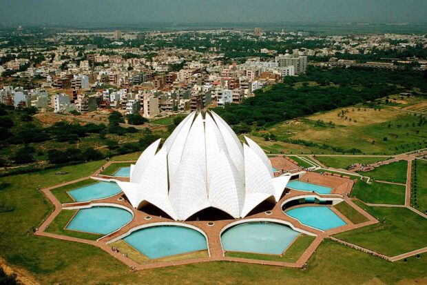 An aerial view of Lotus Temple in New Delhi surrounded by gardens and cityscape