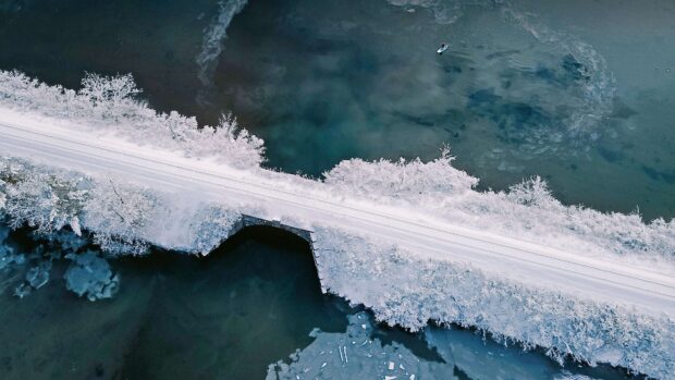 A snowy landscape with a bridge over icy water in New Hampshire