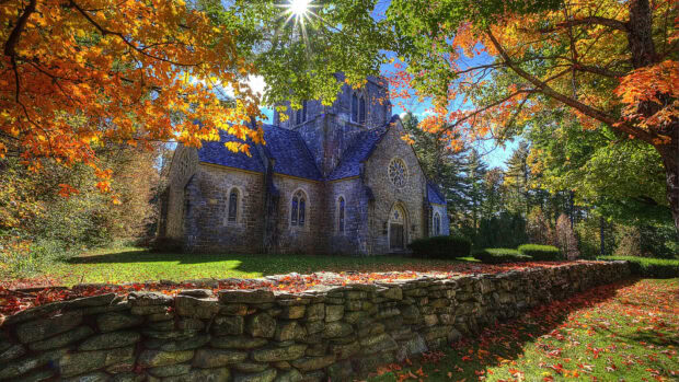 Historic stone church surrounded by autumn foliage in New Hampshire