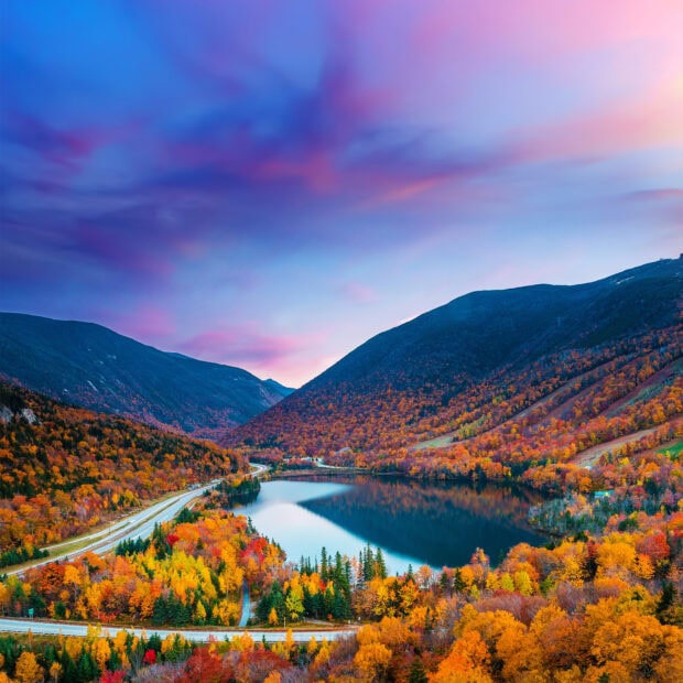 Autumn foliage surrounds a lake and mountains in New Hampshire