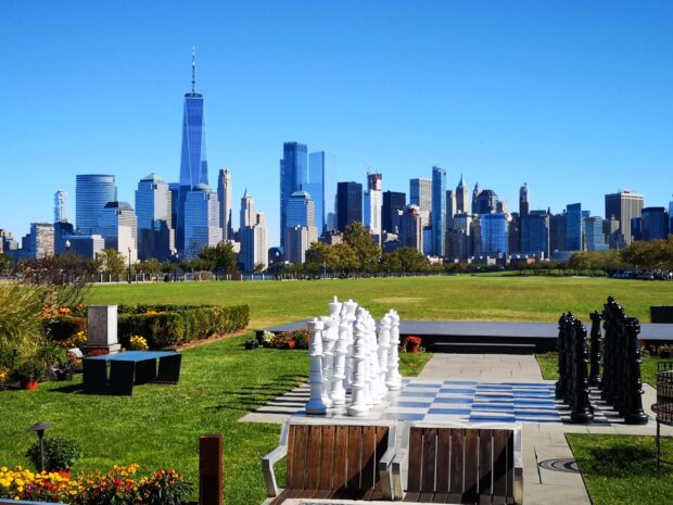 Giant chess set in a park with New Jersey skyline in the background on a clear day