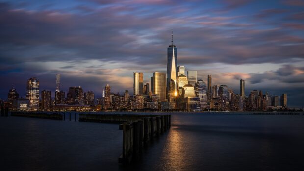 New Jersey city skyline at sunset with glowing skyscrapers and reflective water