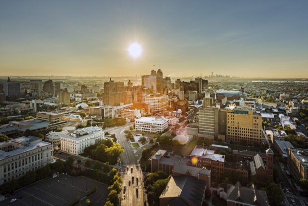 Aerial view of New Jersey city skyline at sunset with sun shining brightly