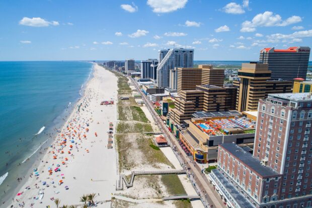 Aerial view of New Jersey coastline with sandy beach and city skyline on a sunny day