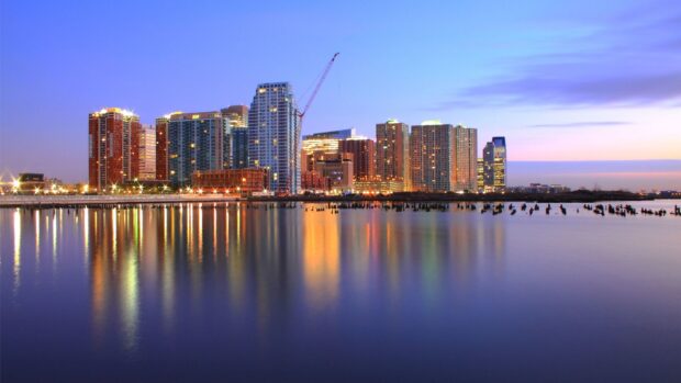 Evening cityscape view of New Jersey skyline reflecting on calm water