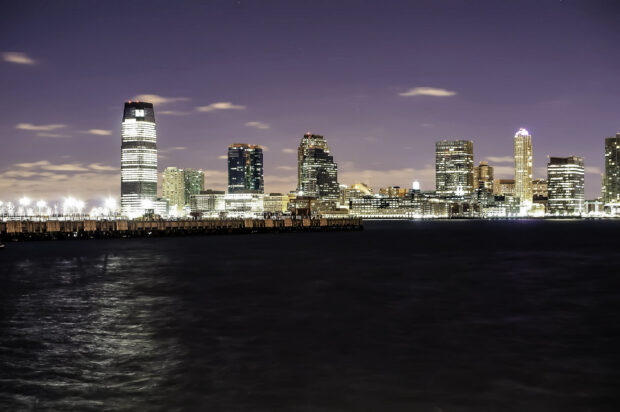 Night view of New Jersey cityscape with illuminated buildings and waterfront