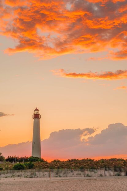 Lighthouse standing tall on the New Jersey coast during a vibrant sunset sky