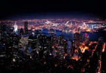 New York city skyline at night with bright lights and illuminated buildings