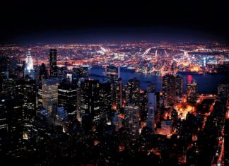 New York city skyline at night with bright lights and illuminated buildings