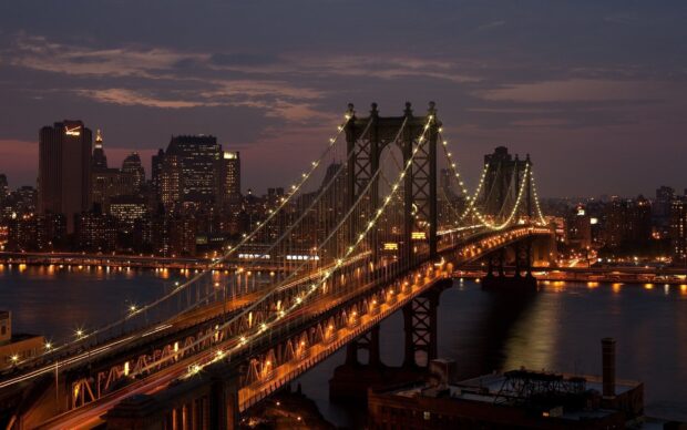 Manhattan Bridge with city lights in New York at night showcasing urban skyline