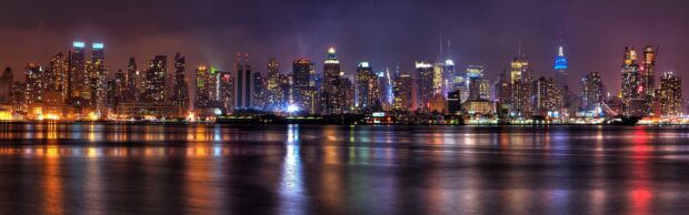 Stunning New York cityscape at night with bright lights reflecting on the water