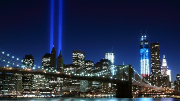The New York skyline with illuminated buildings and twin blue light beams at night