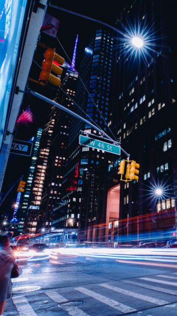The bustling New York street at night with illuminated buildings and vibrant city lights
