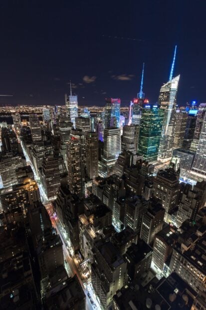 New York cityscape at night with bright lights and tall skyscrapers illuminating the urban skyline