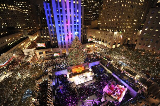 Crowd gathered around the New York Christmas tree lighting ceremony in a festive city setting