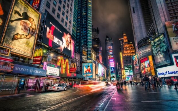 Busy New York streets with bright billboards and McDonalds signs at night
