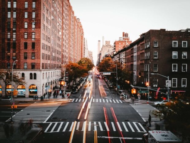 Busy New York streets with tall buildings and light trails at dusk