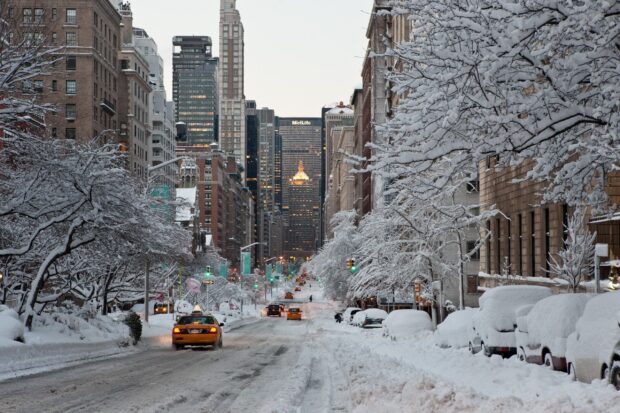 Snow covered New York streets with yellow cabs and snow laden trees in winter