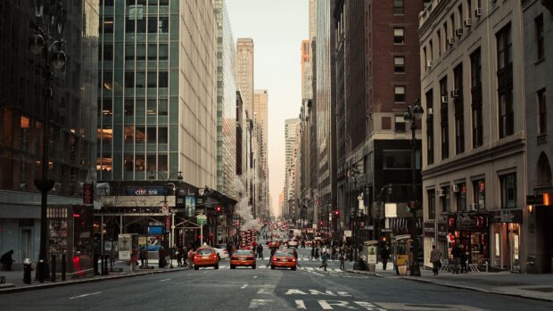 A busy New York Streets scene with taxis and pedestrians walking along city sidewalks