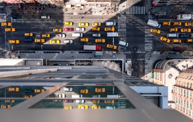 Aerial view of New York streets with yellow taxis and city traffic in clear daylight
